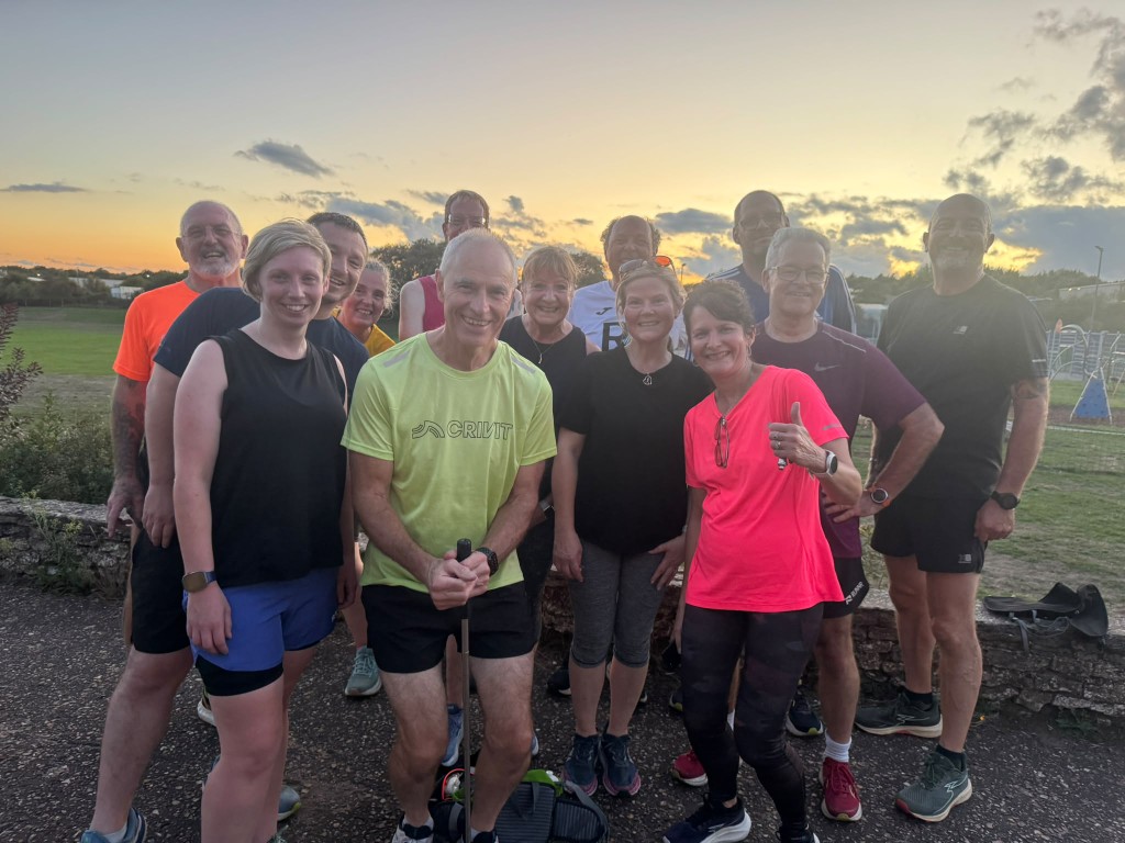 Norfolk Run Collective group smiling together after a session at sunset
